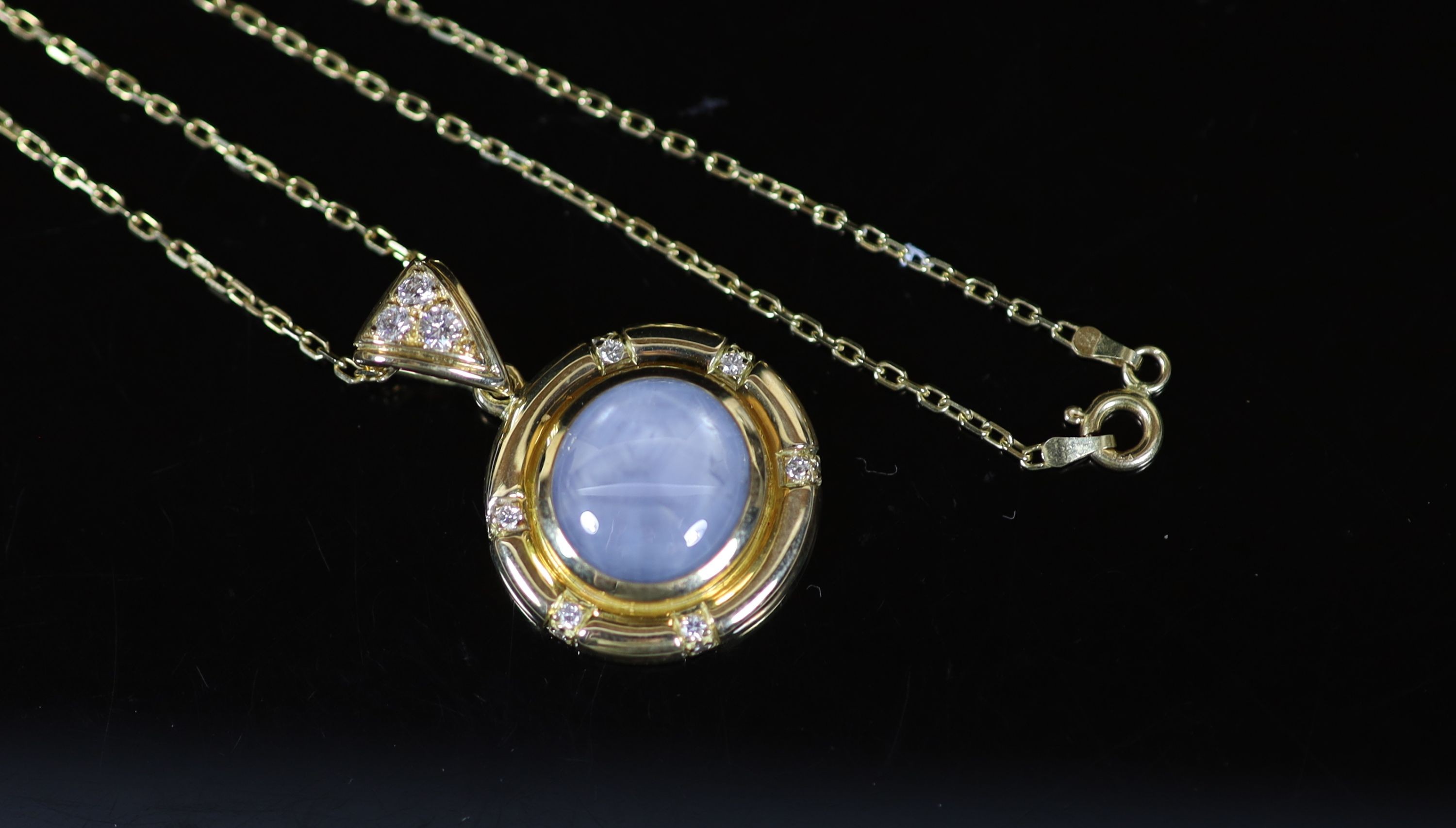 A 20th century French 18ct gold, cabochon star sapphire and diamond set circular pendant, on an 18ct gold fine link chain
